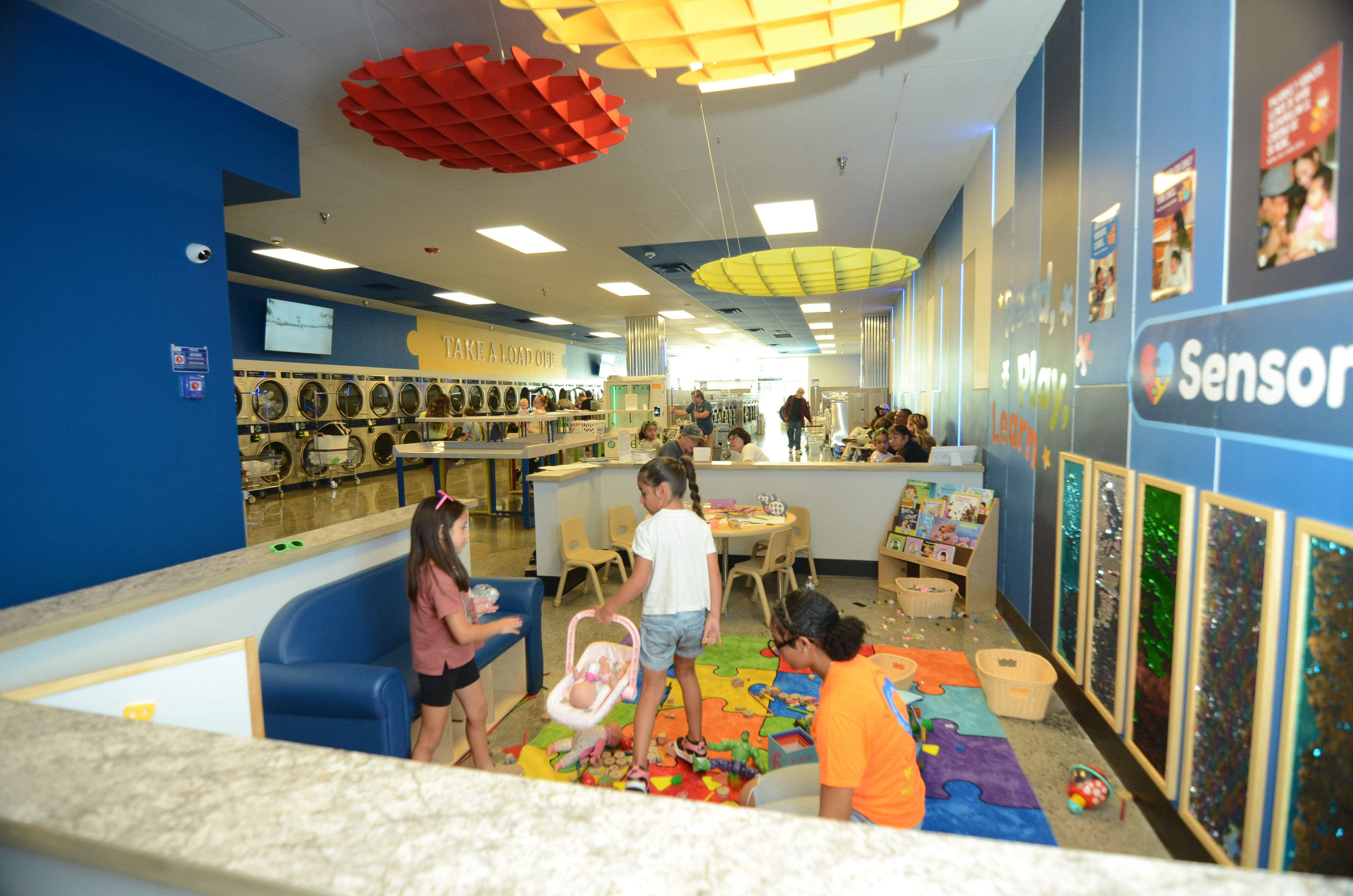 Children and an adult enjoying The Wash’s family activity area