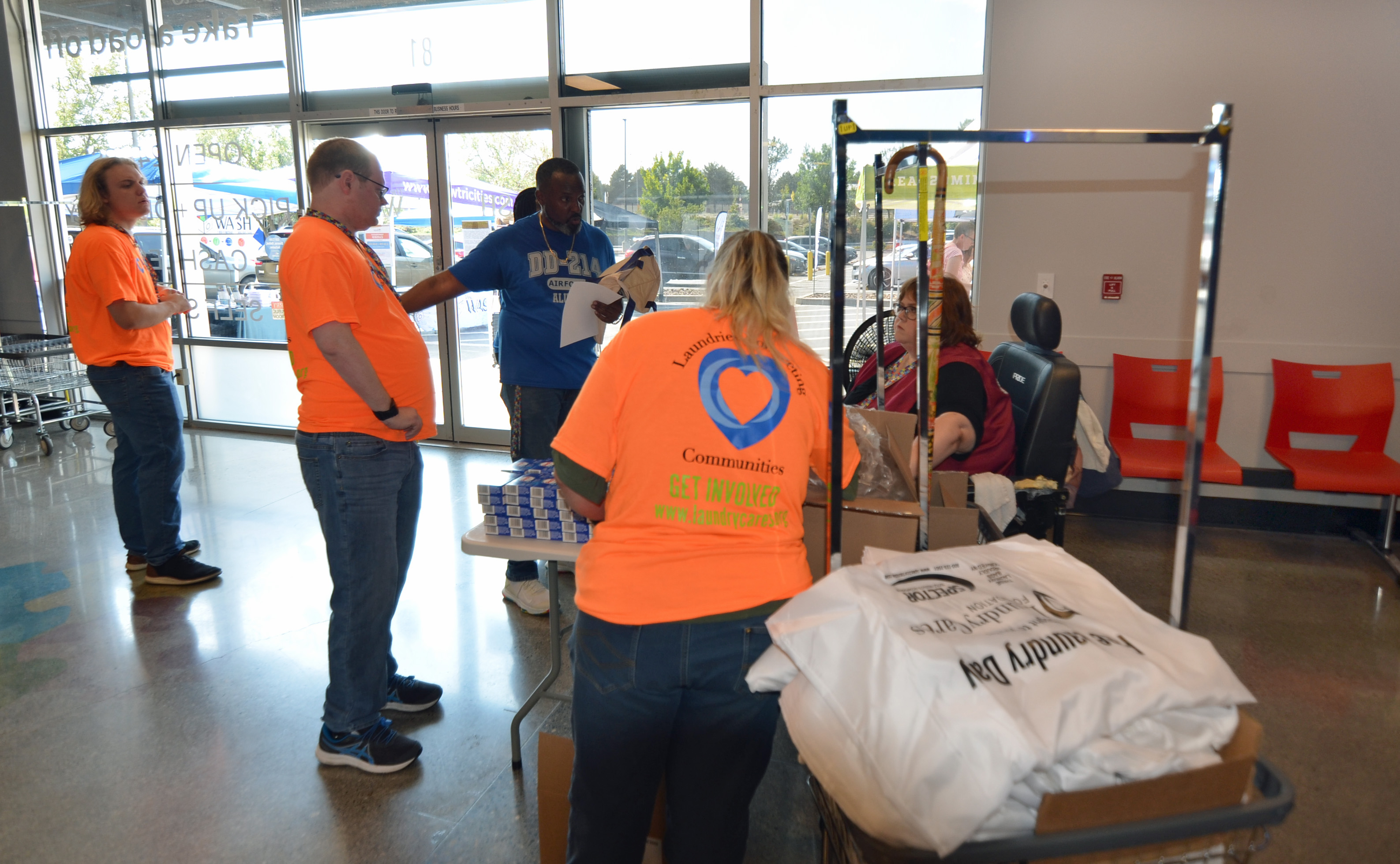 Bags of laundry and visitors near The Wash entrance during Free Laundry Day